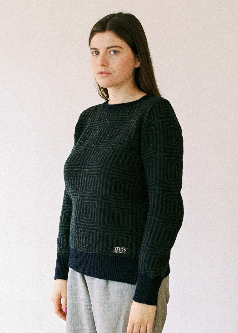 The model with the sweater. The dark colors give it an elegant and discreet touch.