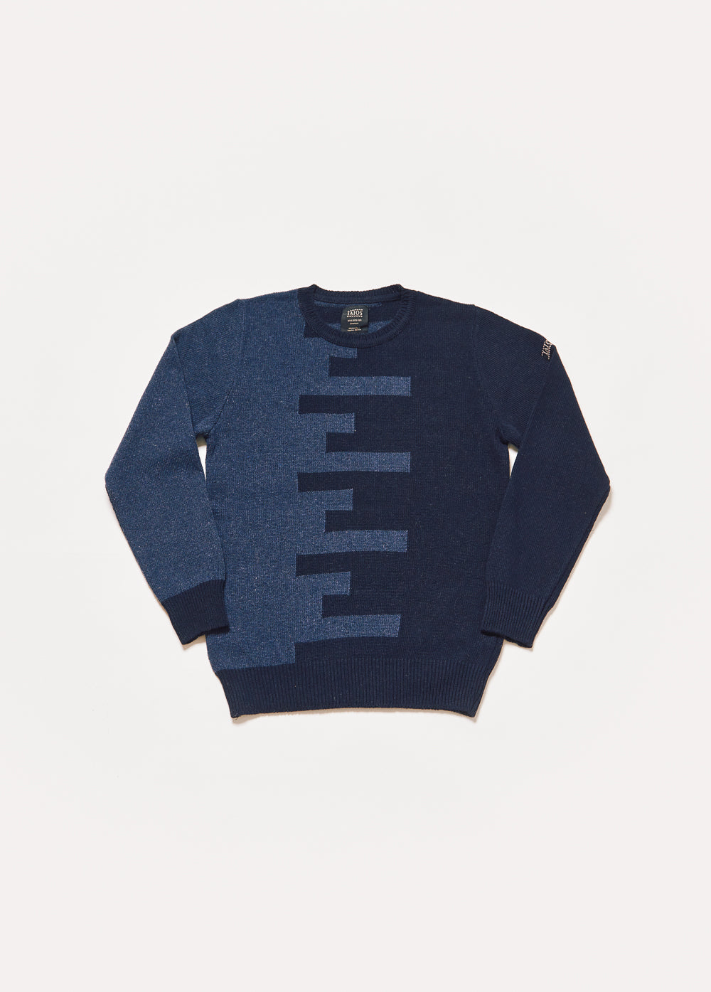 Jersey de punto de hombre o unisex de color azul marino y azul oscuro. El  jersey es de color azul marino del lado derecho y azul oscuro del izquierdo. Ambos se unen en el centro en forma de trama.